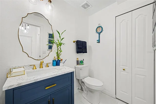 a bathroom with a granite countertop sink a toilet and a mirror