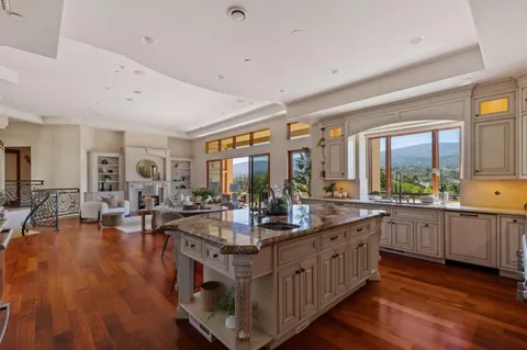 a large kitchen with stainless steel appliances granite countertop a lot of counter space and wooden floors