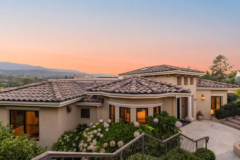 a front view of a house with plants