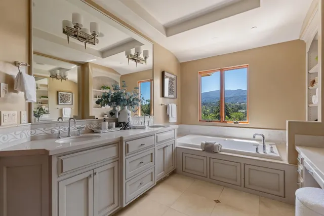 a bathroom with a granite countertop sink mirror bathtub and window