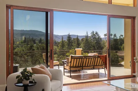 a balcony with furniture and a floor to ceiling window