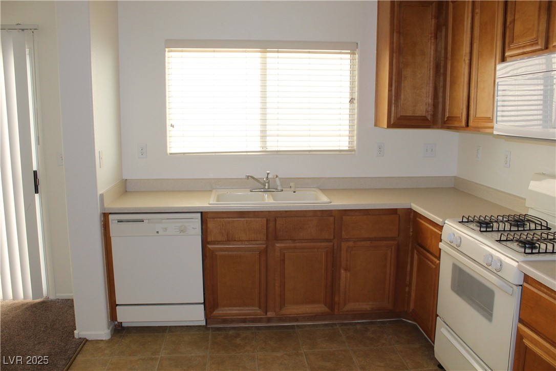 Undisclosed Address Las Vegas, NV 89129 - Photo 4 of 26 Kitchen with brown cabinetry, light countertops, w