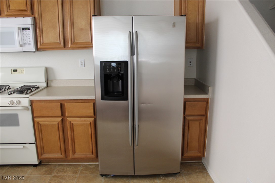 Undisclosed Address Las Vegas, NV 89129 - Photo 9 of 26 Kitchen with brown cabinets, white appliances, and