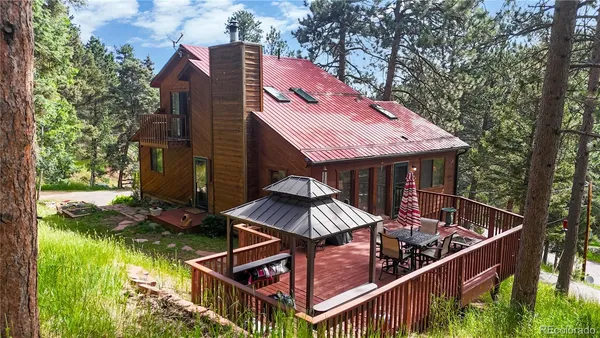 an aerial view of a house roof deck with table and chairs and wooden fence
