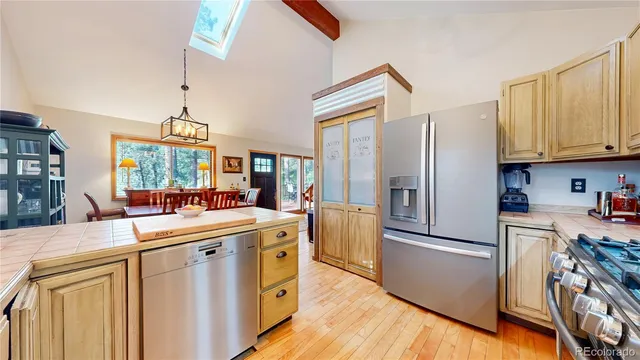 a kitchen with stainless steel appliances a refrigerator a sink a stove and white cabinets
