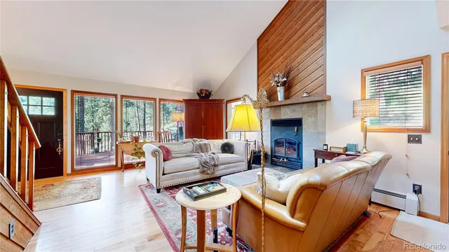 a living room with fireplace furniture and a large window