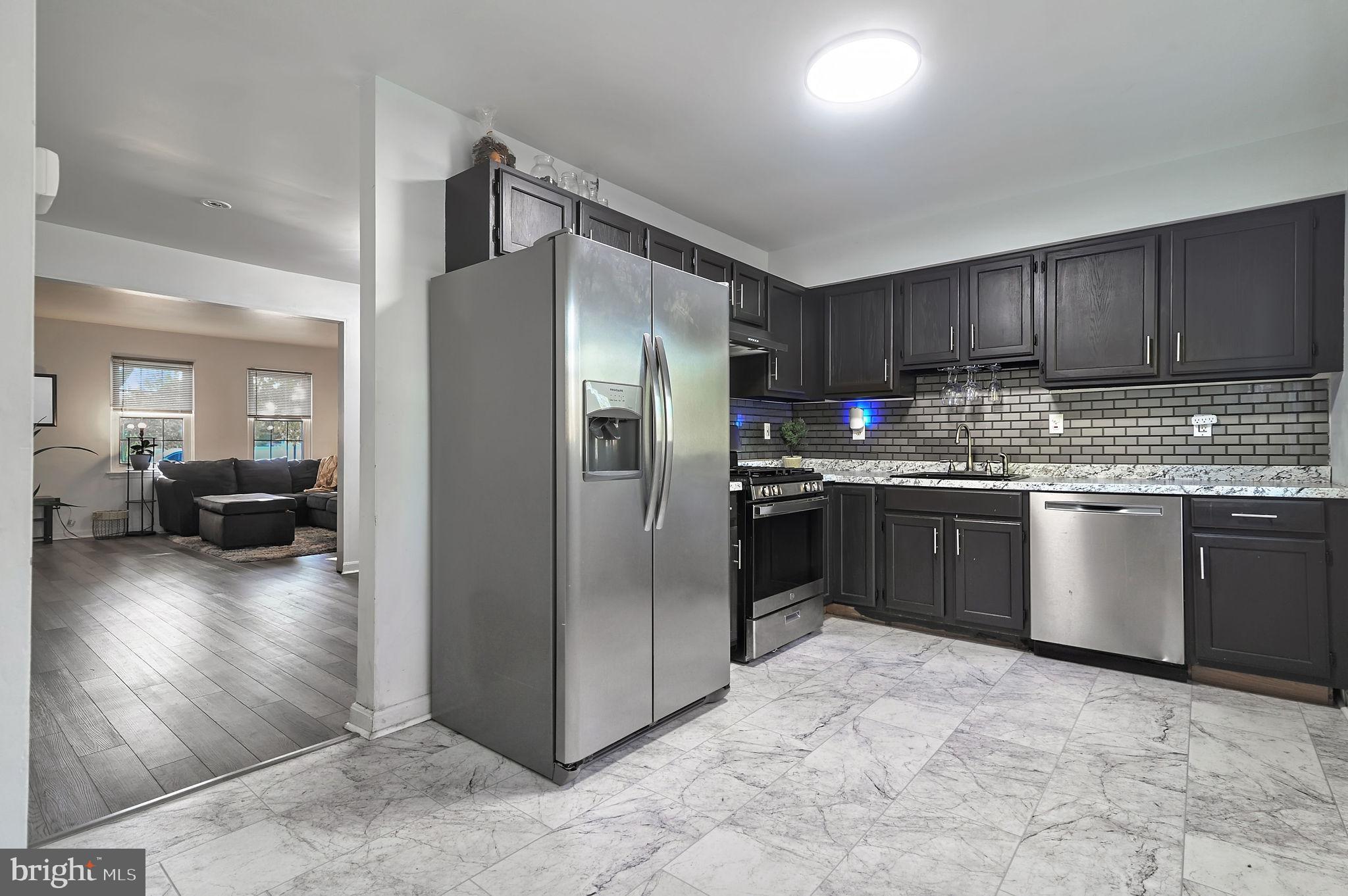 147 Holmes Street Dover, DE 19901 - Photo 7 of 19 a kitchen with stainless steel appliances granite countertop a refrigerator a stove a sink and a refrigerator