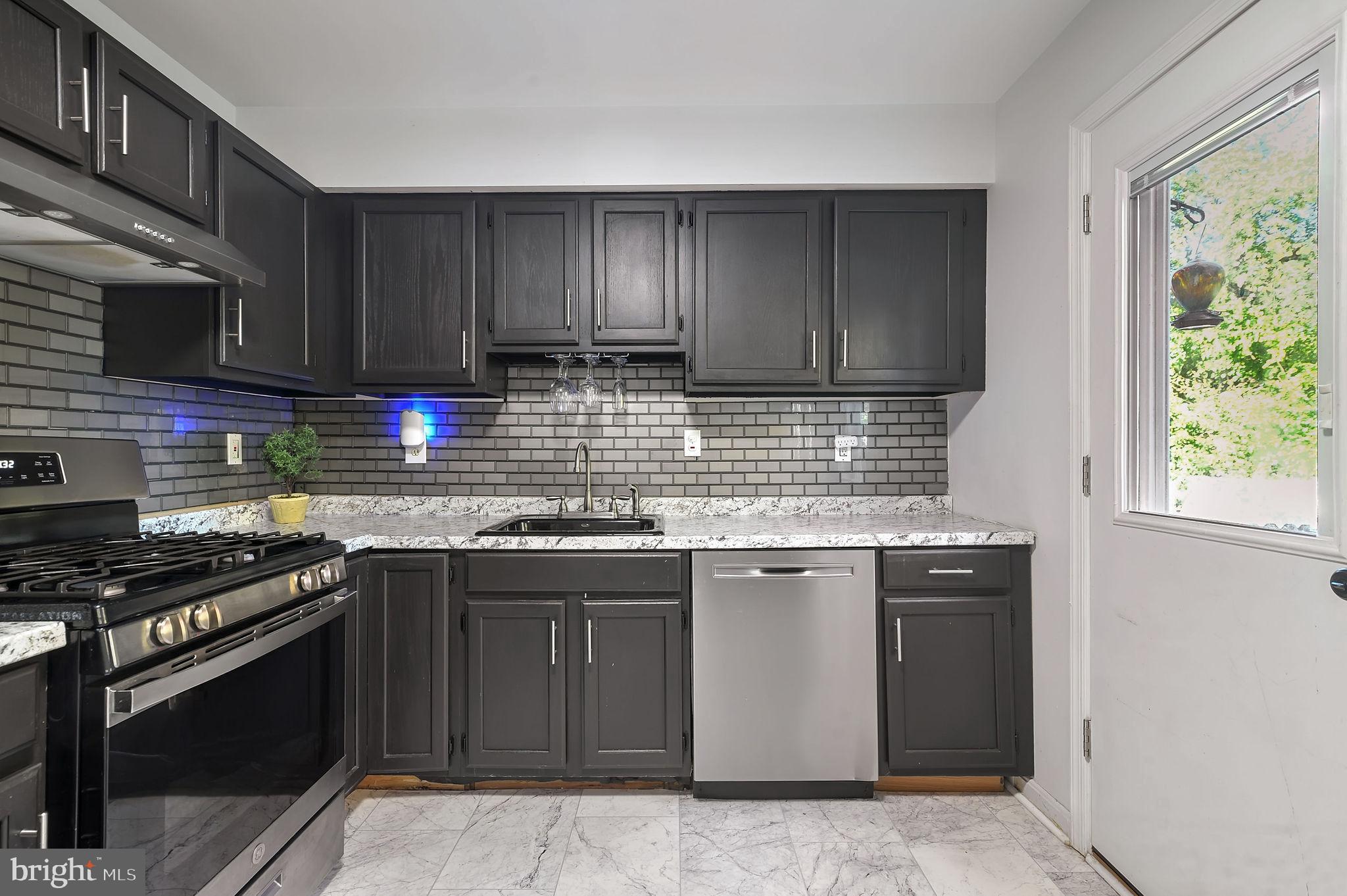 147 Holmes Street Dover, DE 19901 - Photo 8 of 19 a kitchen with stainless steel appliances granite countertop a stove a sink and a microwave