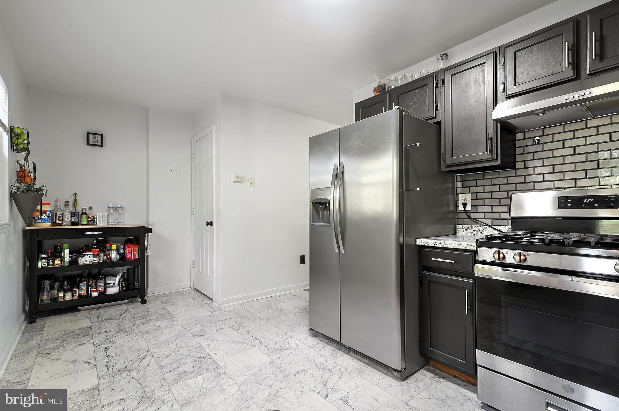 147 Holmes Street Dover, DE 19901 - Photo 9 of 19 a kitchen with stainless steel appliances granite countertop a refrigerator and a stove