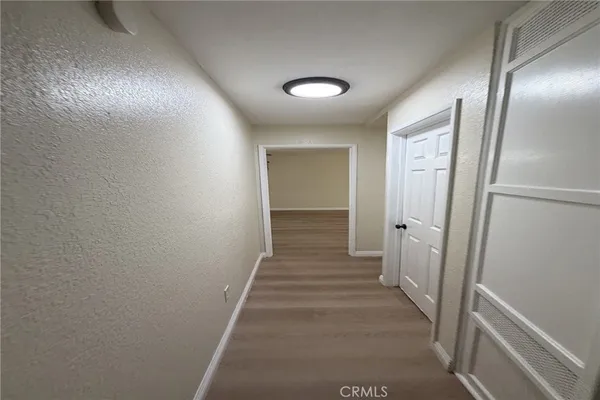 a view of a hallway with wooden floor and staircase