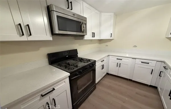 a kitchen with white cabinets stainless steel appliances and sink