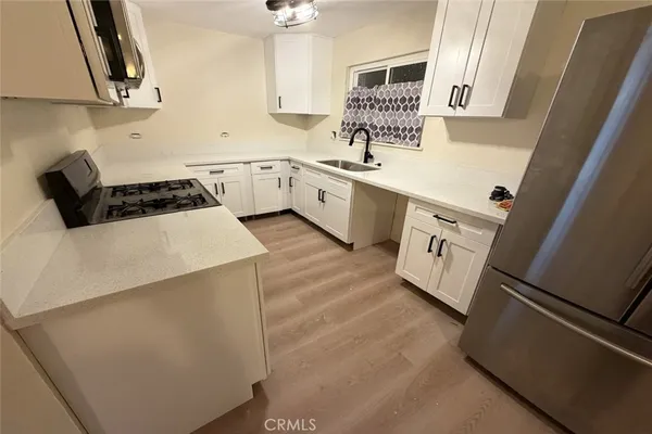 a kitchen with a sink a stove and cabinets
