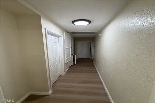 a view of a hallway with wooden floor and staircase