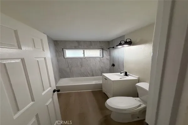 a white toilet sitting next to a bathroom sink and tub