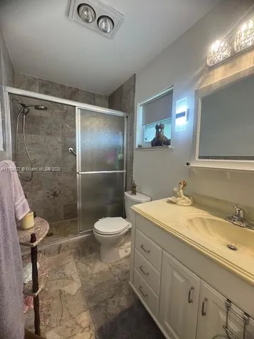 a spacious bathroom with a double vanity sink a toilet and a large mirror