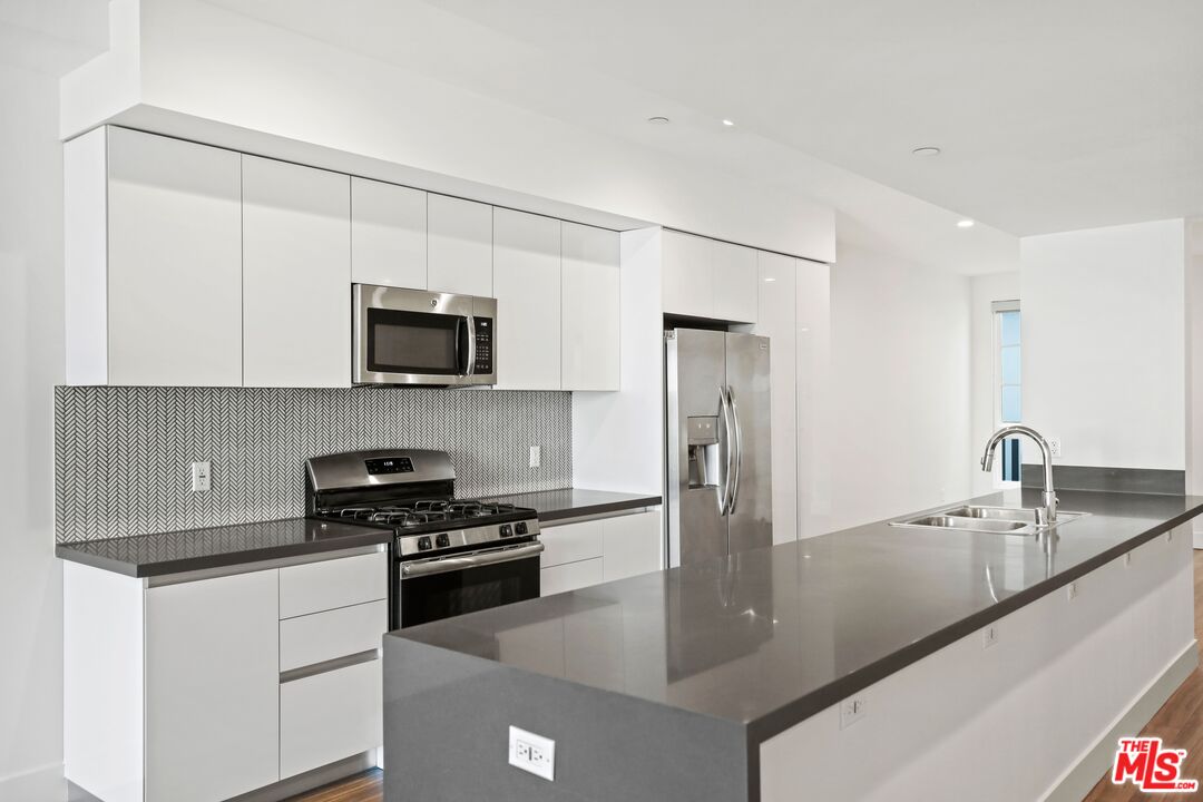11847 Kiowa Avenue, Unit PH6 Los Angeles, CA 90049 - Photo 3 of 18 a kitchen with stainless steel appliances granite countertop a sink a stove and a refrigerator