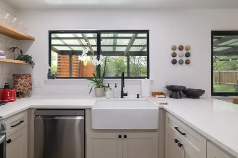 a kitchen with a sink a window and cabinets