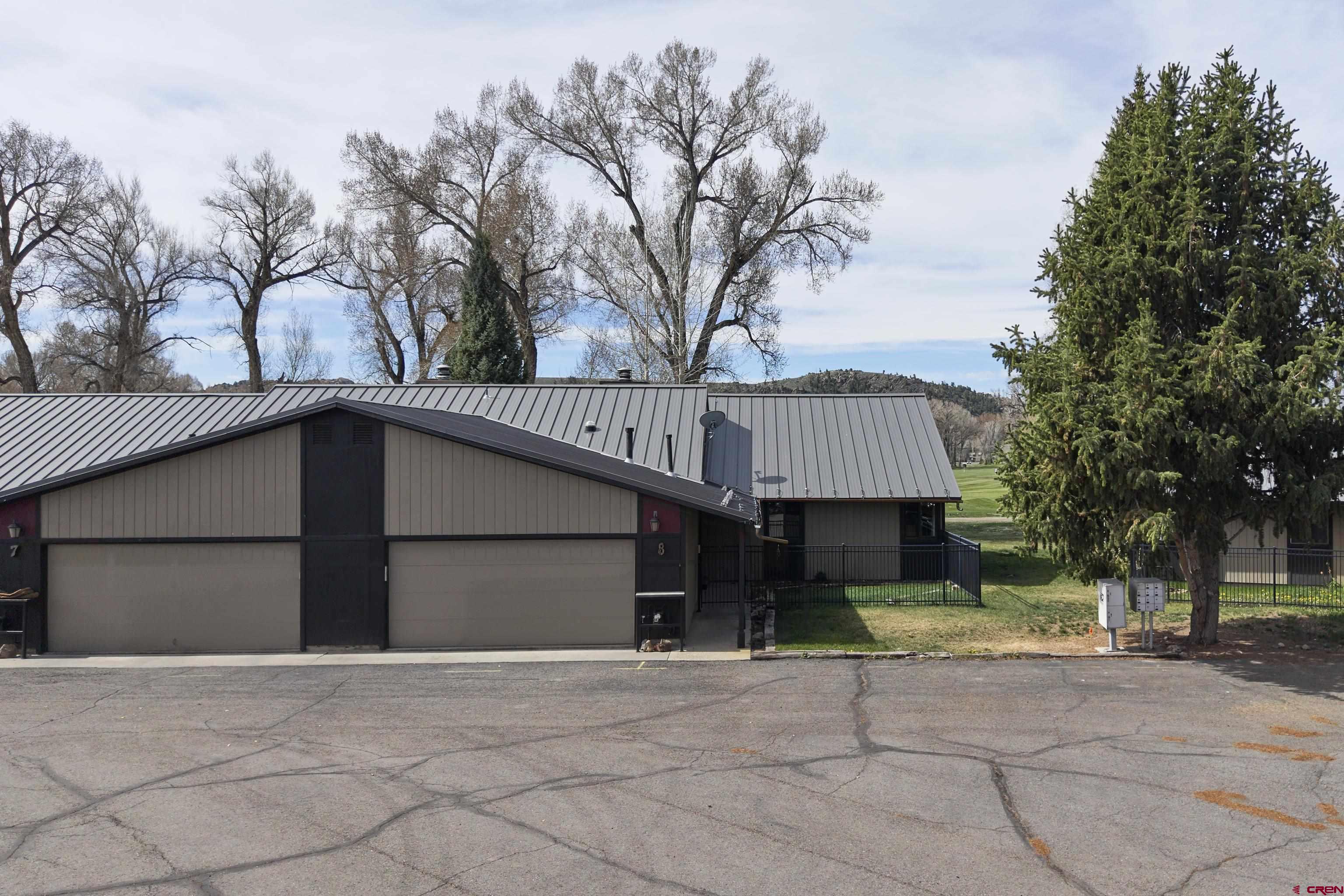 169 Camino Del Rio, Unit 8 Gunnison, CO 81230 - Photo 2 of 45 a front view of a house with a yard and garage