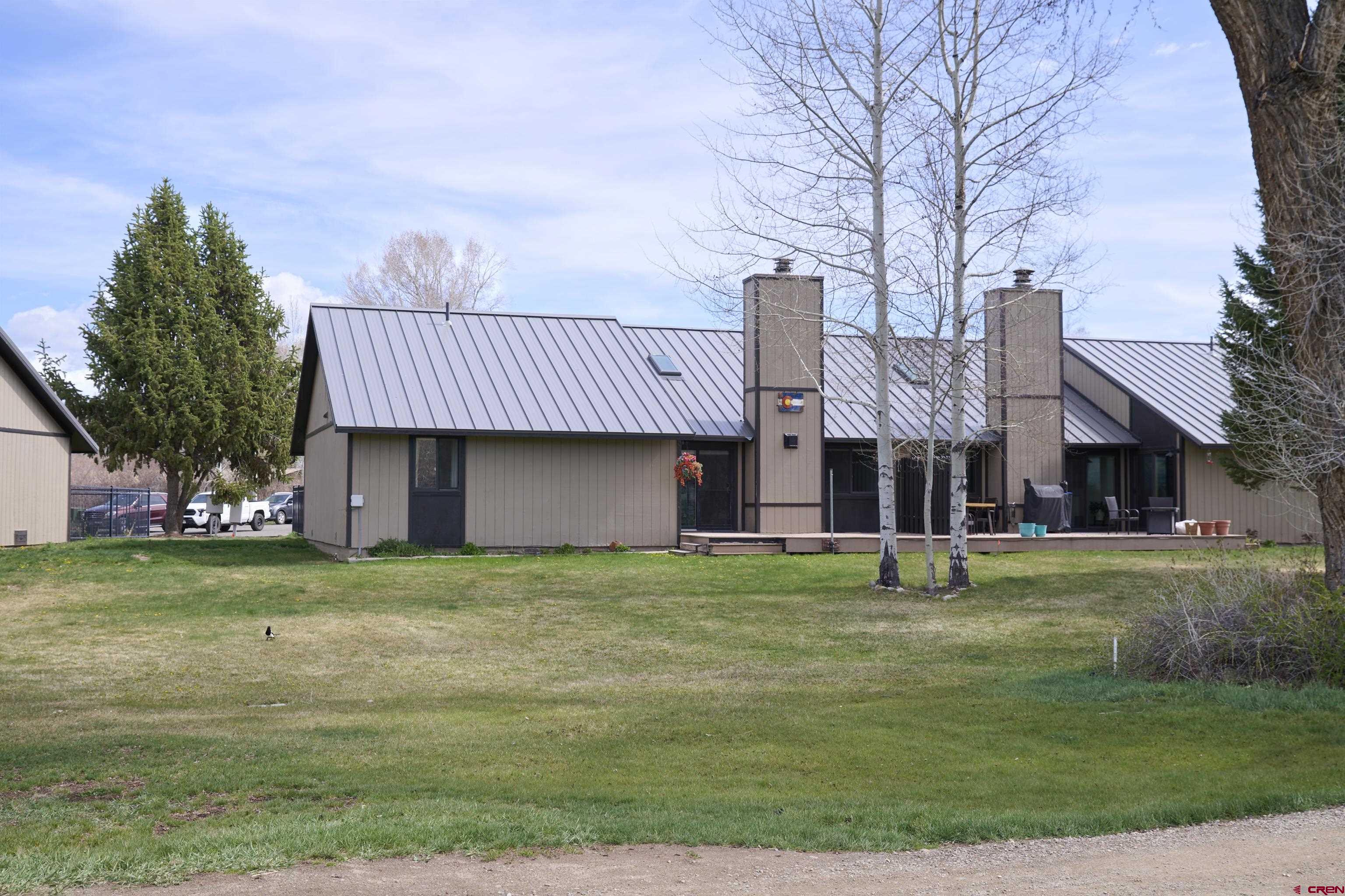 169 Camino Del Rio, Unit 8 Gunnison, CO 81230 - Photo 45 of 45 a view of a big house with a big yard and large trees