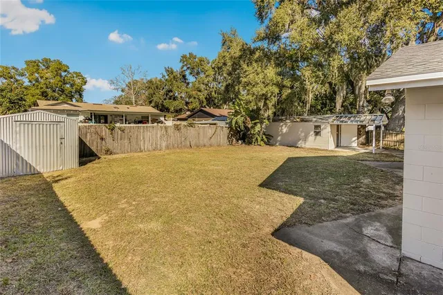 a view of a house with a yard and potted plants