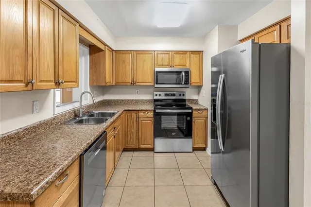 a kitchen with stainless steel appliances granite countertop a refrigerator stove and sink