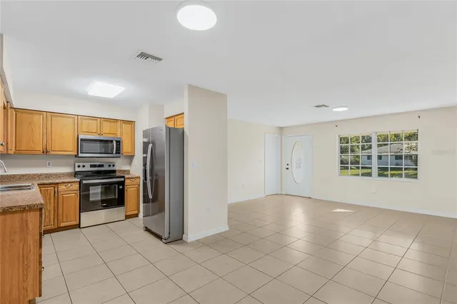 a view of a kitchen with a sink stove cabinets and empty room
