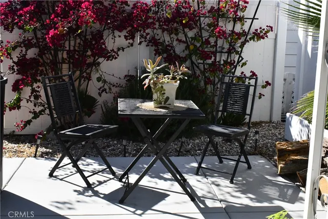 a kitchen with stainless steel appliances granite countertop a refrigerator a sink dishwasher a dining table and chairs with wooden floor