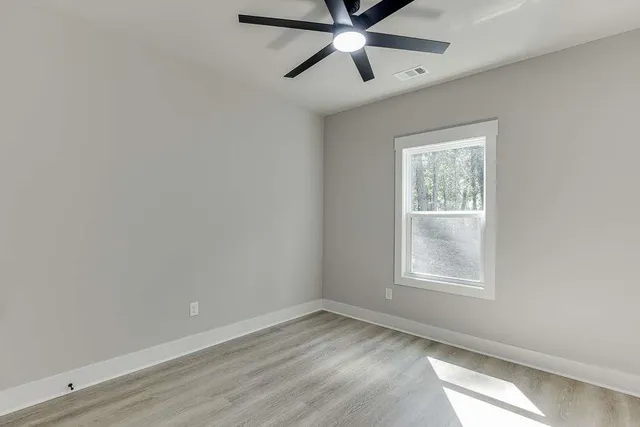 an empty room with a window and a fan