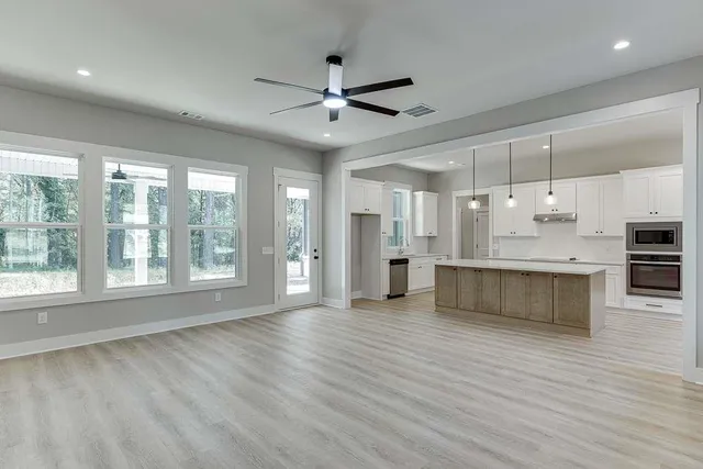 a view of an empty room with kitchen appliances and a window