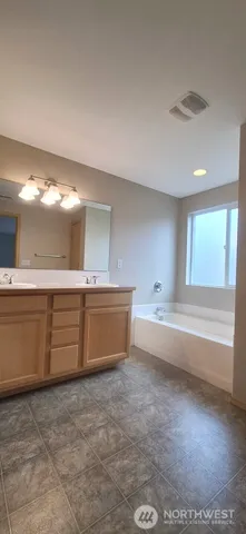a bathroom with a tub sink and mirror