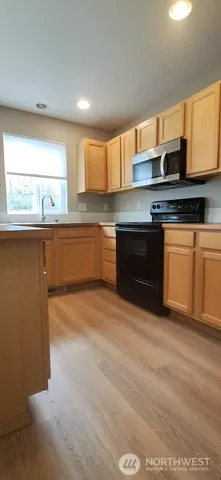 a kitchen with stainless steel appliances granite countertop a stove a sink and a microwave