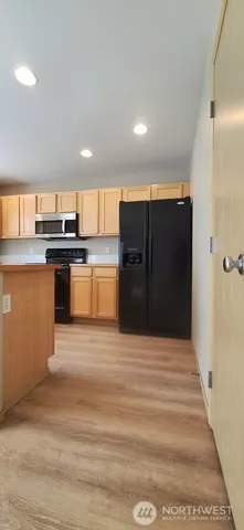 a kitchen with stainless steel appliances granite countertop a refrigerator and a stove top oven
