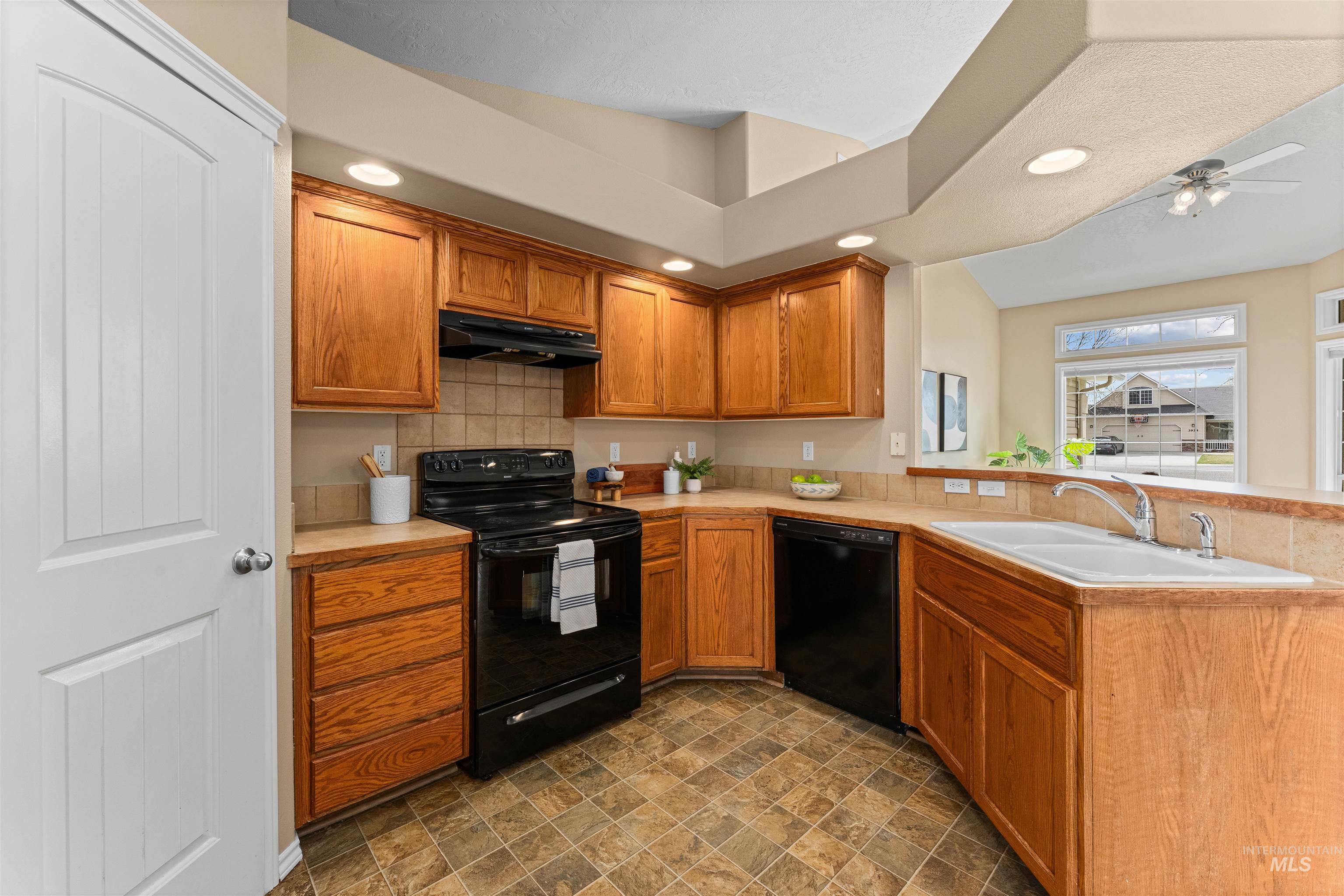 3923 Chatham Court Caldwell, ID 83607 - Photo 11 of 32 Kitchen featuring black appliances, a peninsula, light countertops, wood finish cabinetry, and recessed lighting