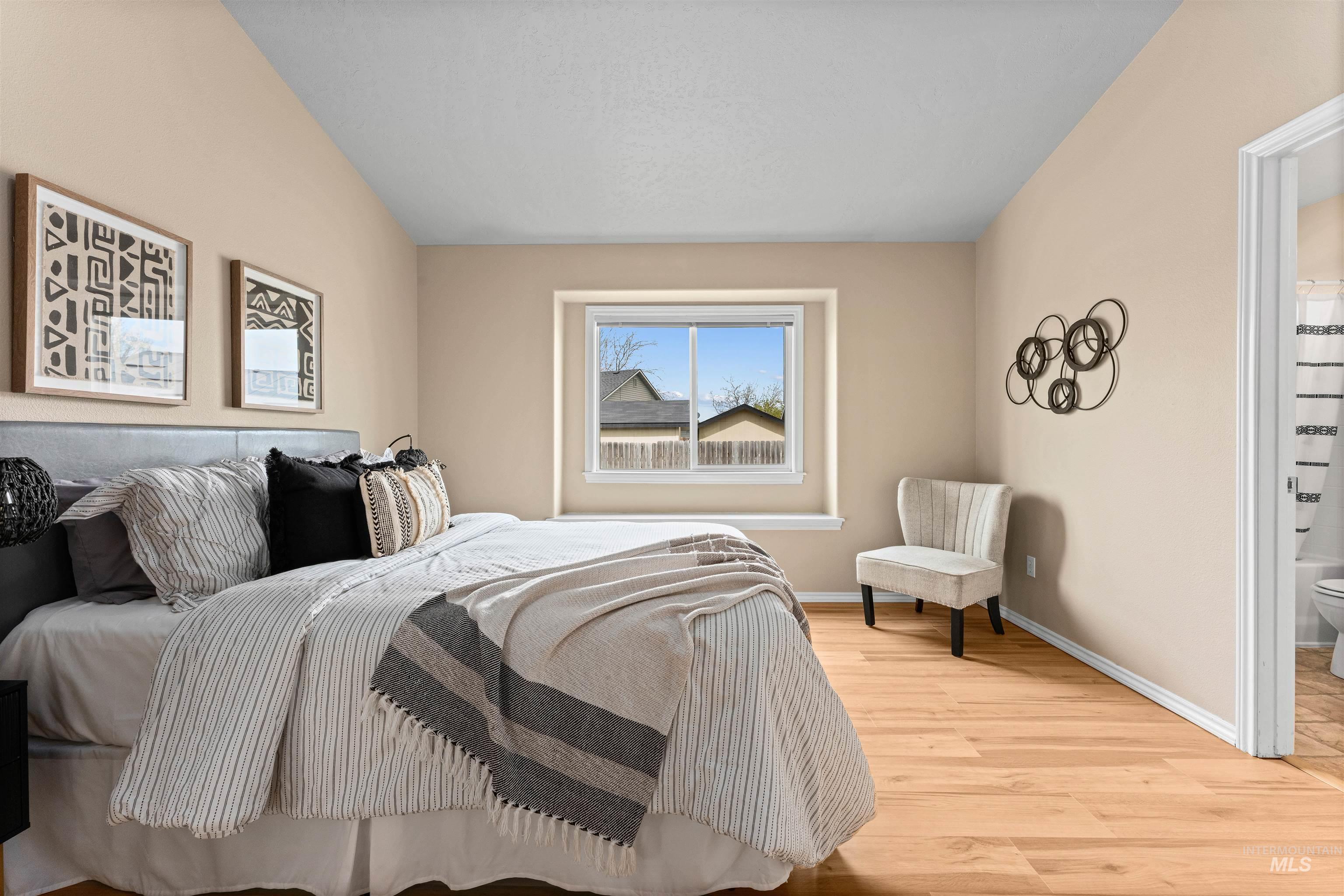 3923 Chatham Court Caldwell, ID 83607 - Photo 14 of 32 Bedroom with light wood finished floors, connected bathroom, and vaulted ceiling