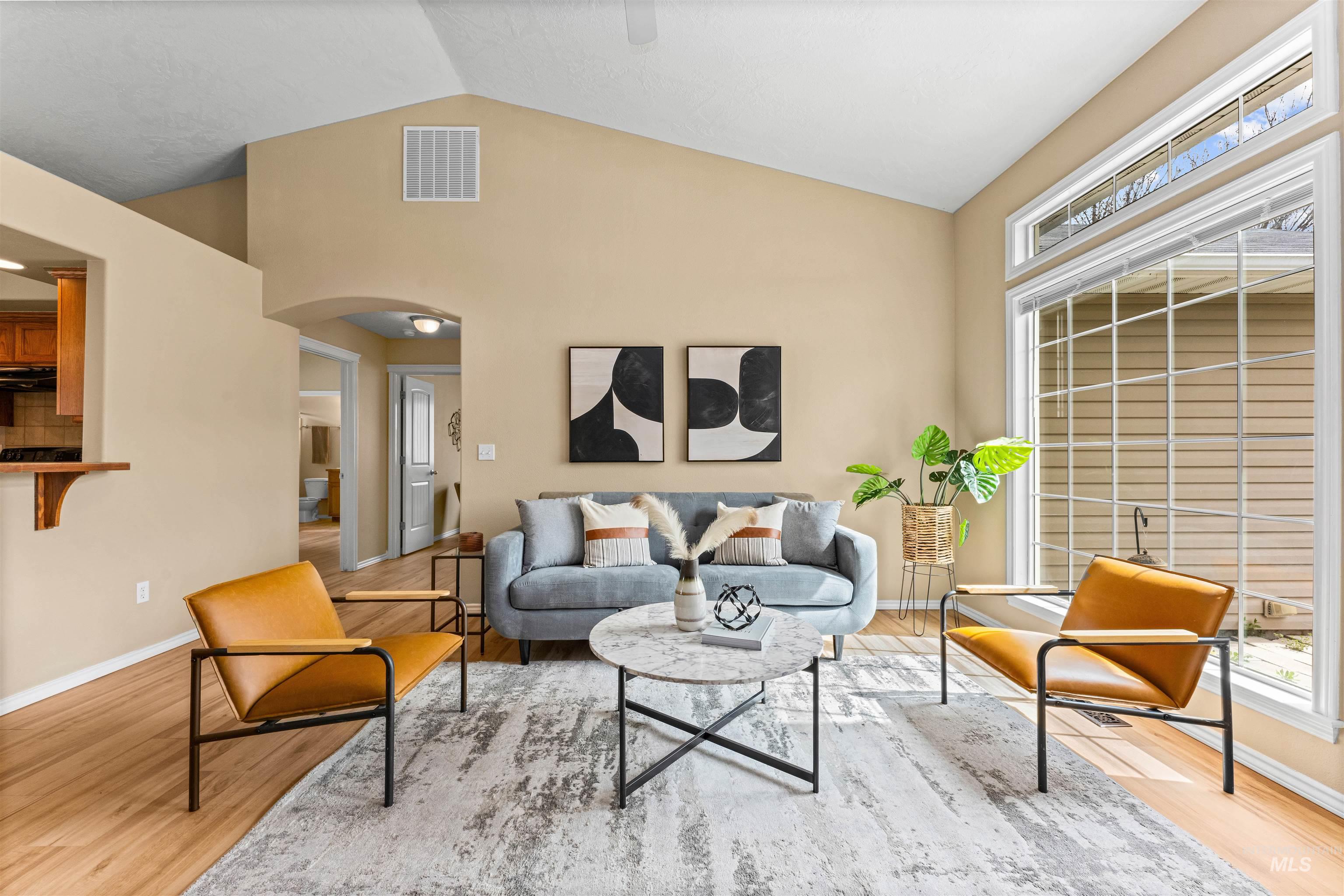 3923 Chatham Court Caldwell, ID 83607 - Photo 5 of 32 Living area featuring arched walkways, vaulted ceiling, plenty of natural light, and light wood finished floors
