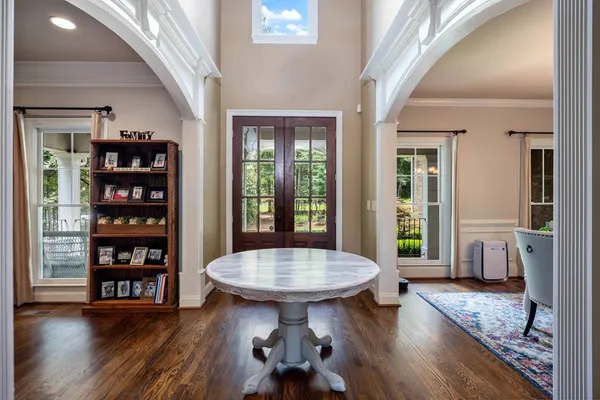a living room with furniture and a piano next to a large window