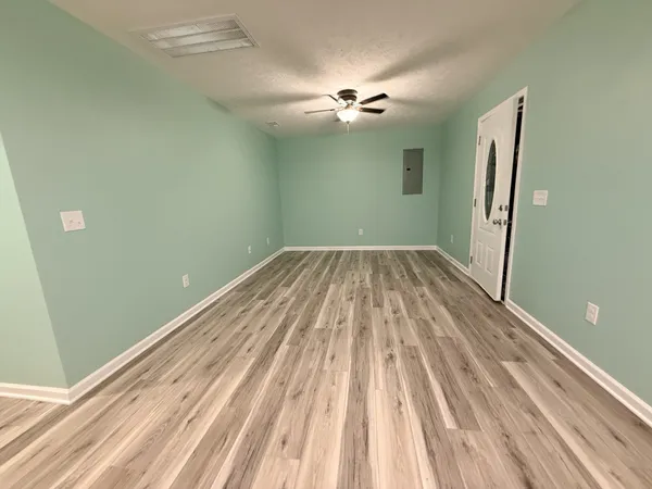 a view of a room with wooden floor and fan