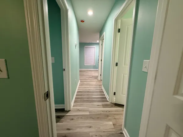 a view of a hallway with wooden floor and stairs