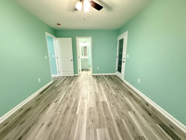 a view of a room with a ceiling fan and window