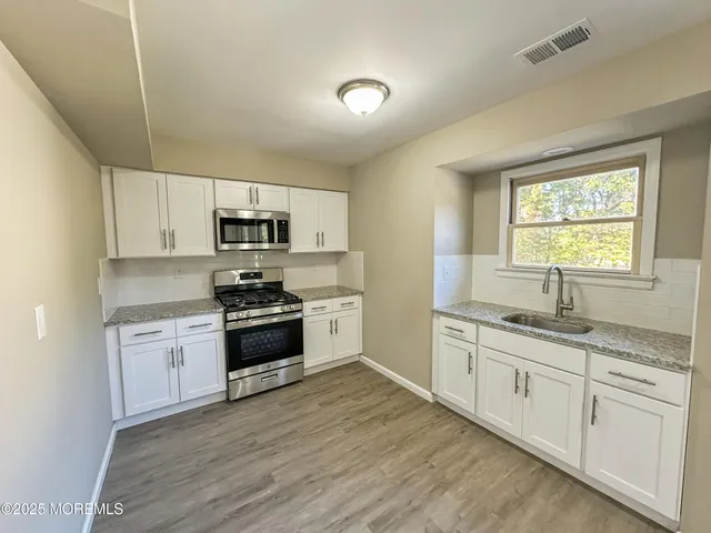 a open dining room with furniture and wooden floor