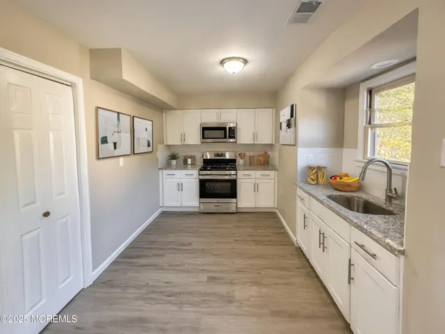 a large kitchen with a stove top oven and sink