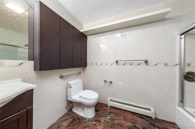 a white toilet sitting next to a bathroom sink and vanity
