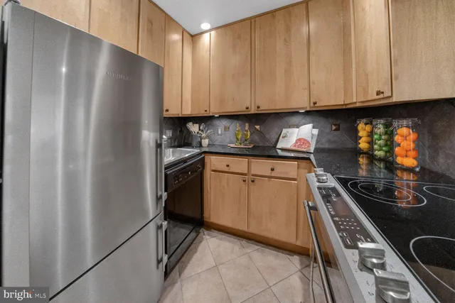 a kitchen with stainless steel appliances granite countertop a refrigerator and a stove
