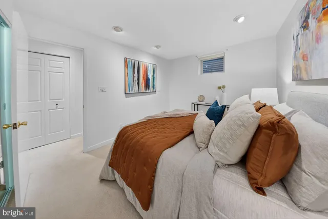 a bedroom with a bed and painting on the wall