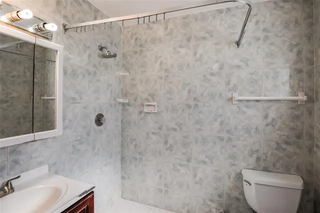 a bathroom with a shower toilet and sink