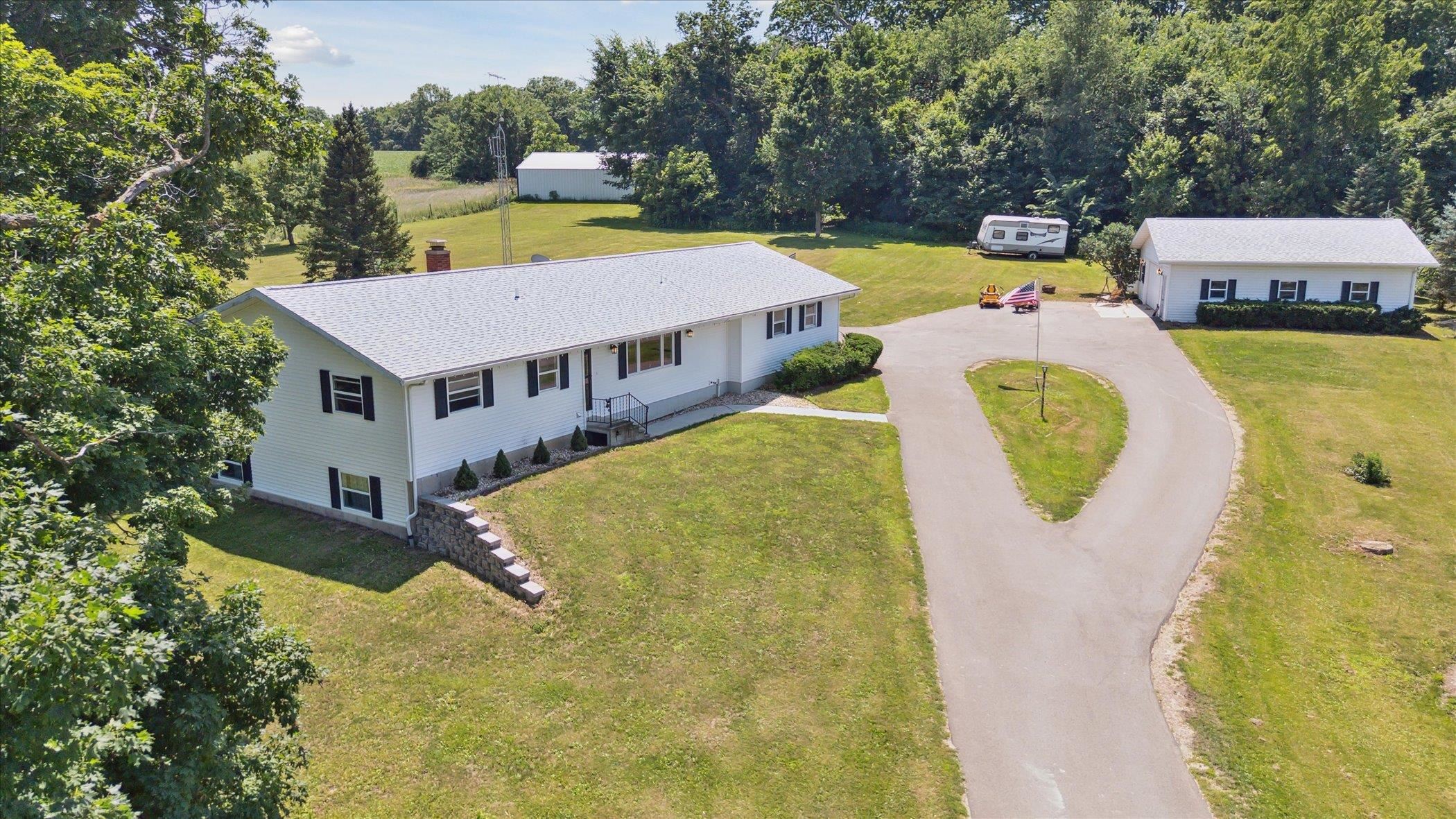 505 East State Line Road Orangeville, IL 61060 - Photo 1 of 58 a aerial view of a house with swimming pool and large trees