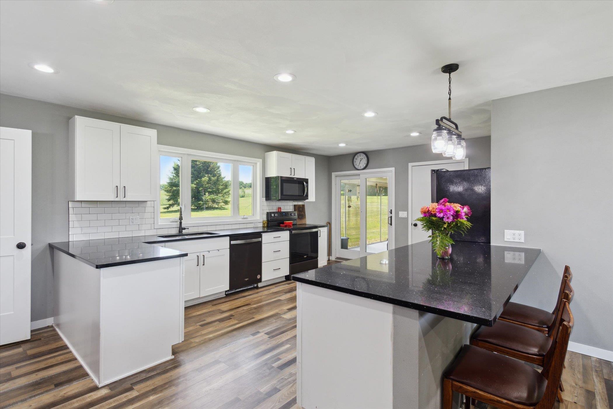 505 East State Line Road Orangeville, IL 61060 - Photo 11 of 58 a kitchen with stainless steel appliances granite countertop a kitchen island hardwood floor sink stove dining table and chairs