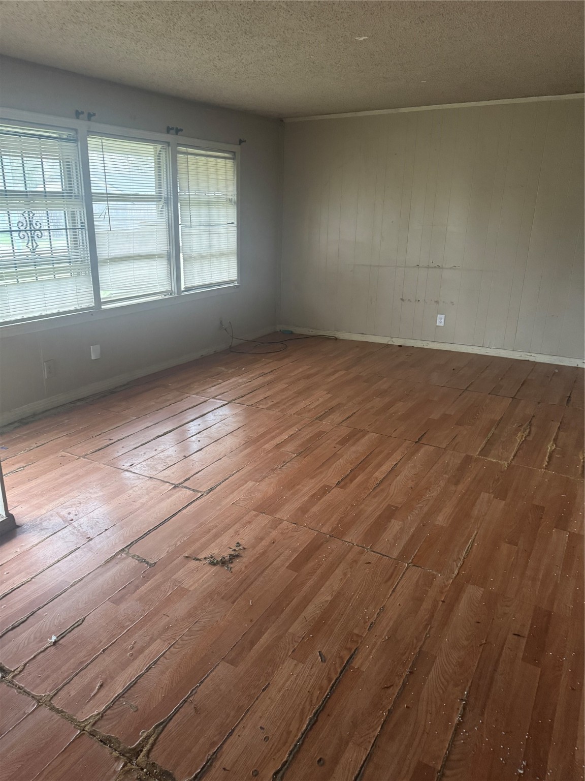 5950 Doolittle Boulevard Houston, TX 77033 - Photo 4 of 25 an empty room with wooden floor and windows