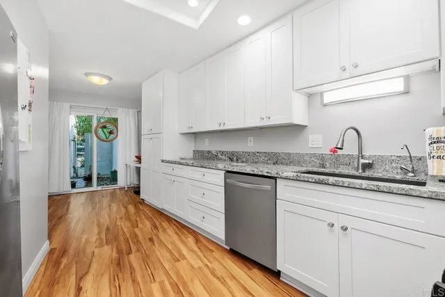 a view of an empty room with wooden floor and window