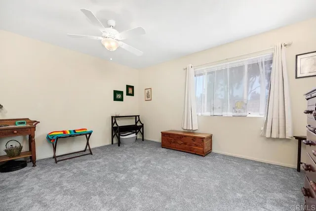 an empty room with furniture and a ceiling fan